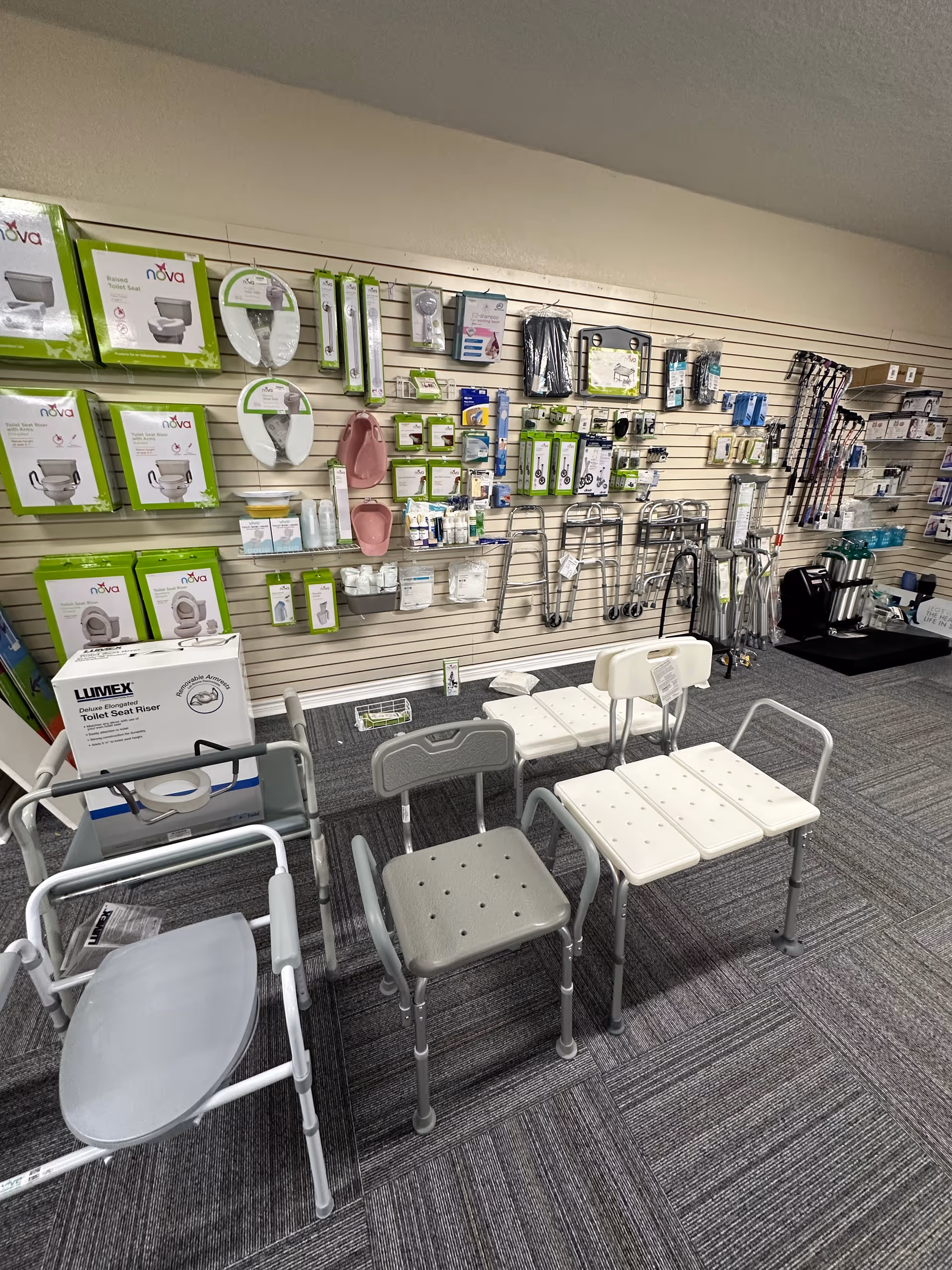 Indoor showroom of medical supplies with walkers, chairs, and bath safety devices on shelves.