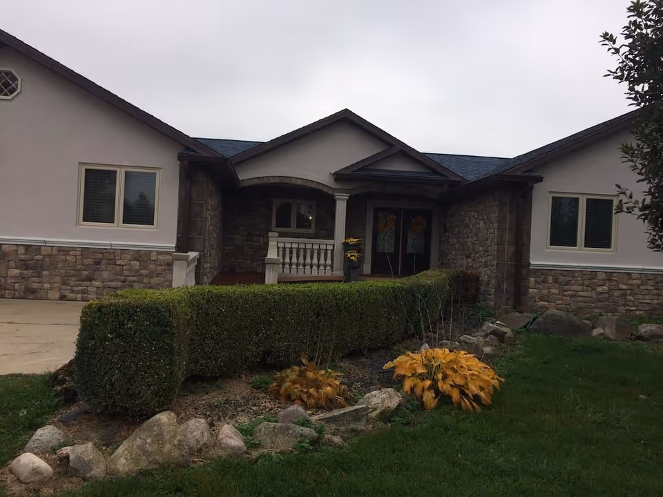 Front view of Riverside Village Homes Unit I exterior with stone accents and landscaping