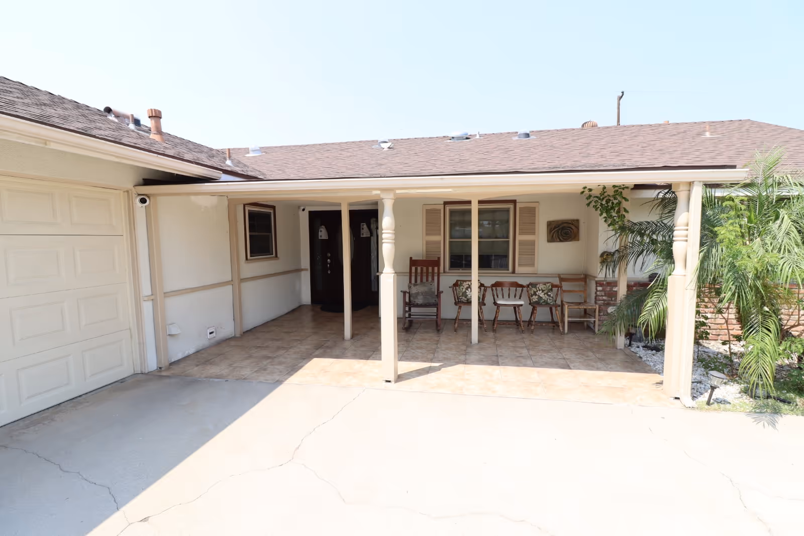 Covered front porch with chairs and columns, leading to a single-story facility entrance.