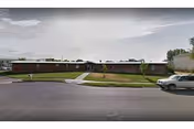 Exterior view of Green Gables facility: single-story building, manicured lawn, and parked car.