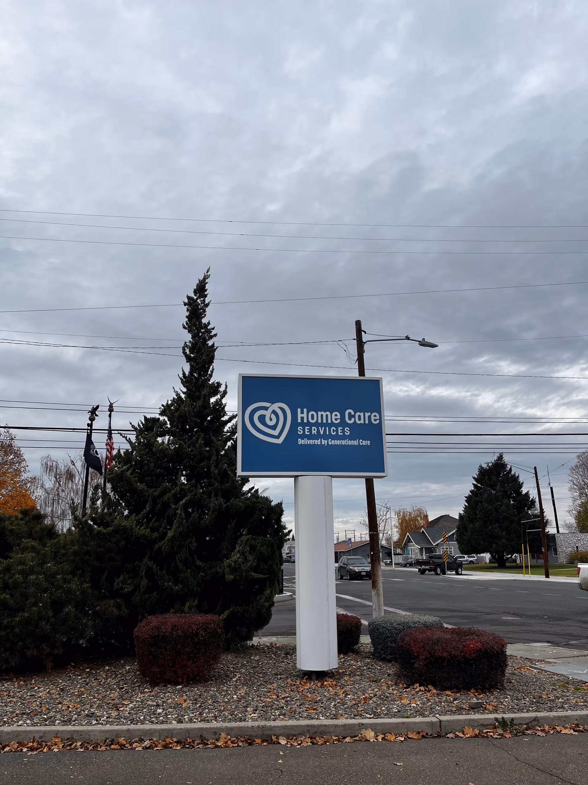 Blue Home Care Services Sunnyside sign on a white post with landscaping.