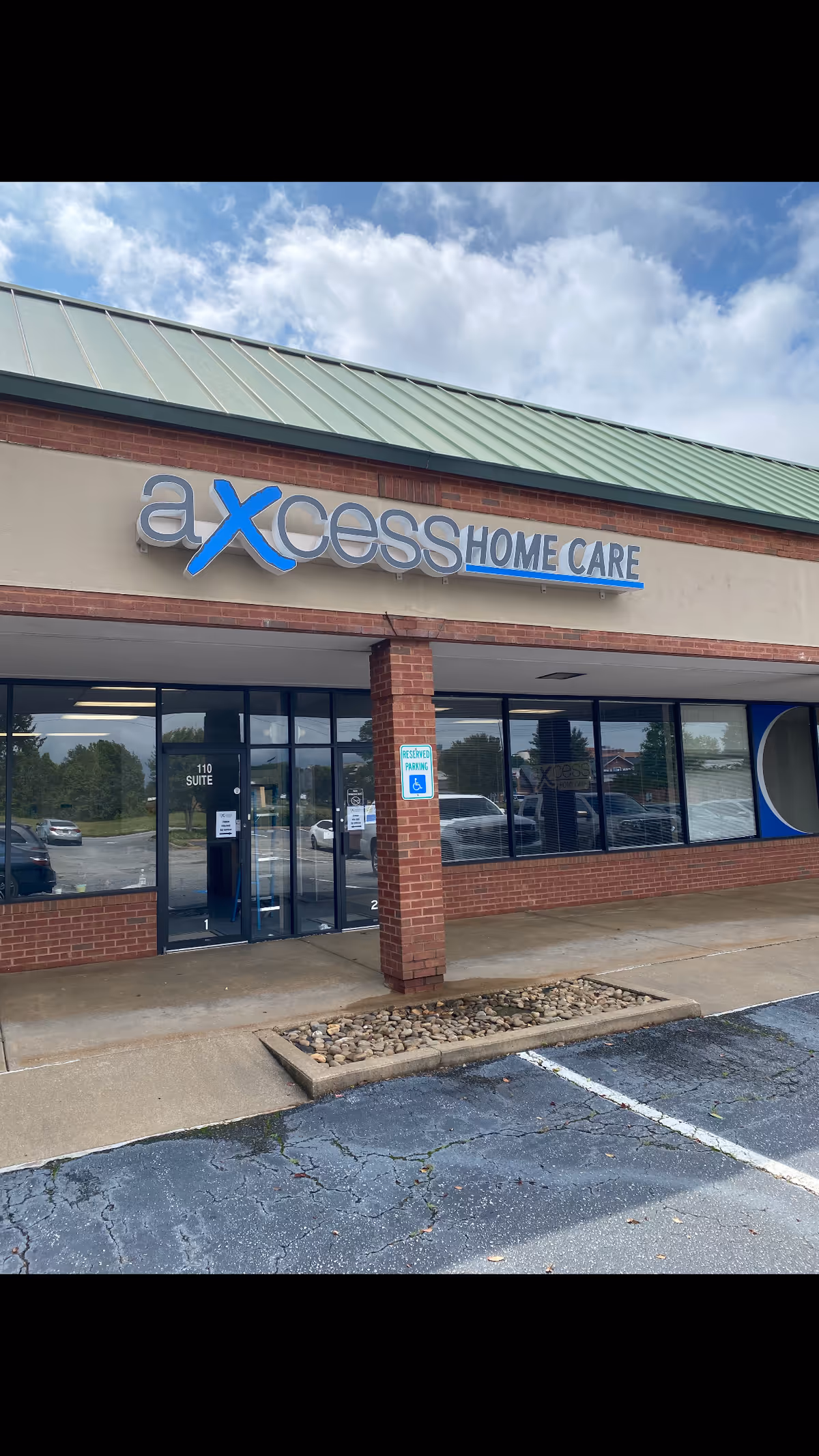 Exterior of Axcess Home Care building with a glass entry and parking.