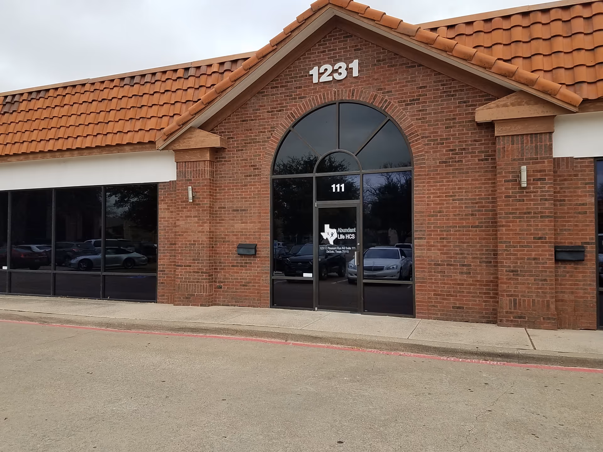Brick-front senior living facility with arched glass doors and 1231 address.