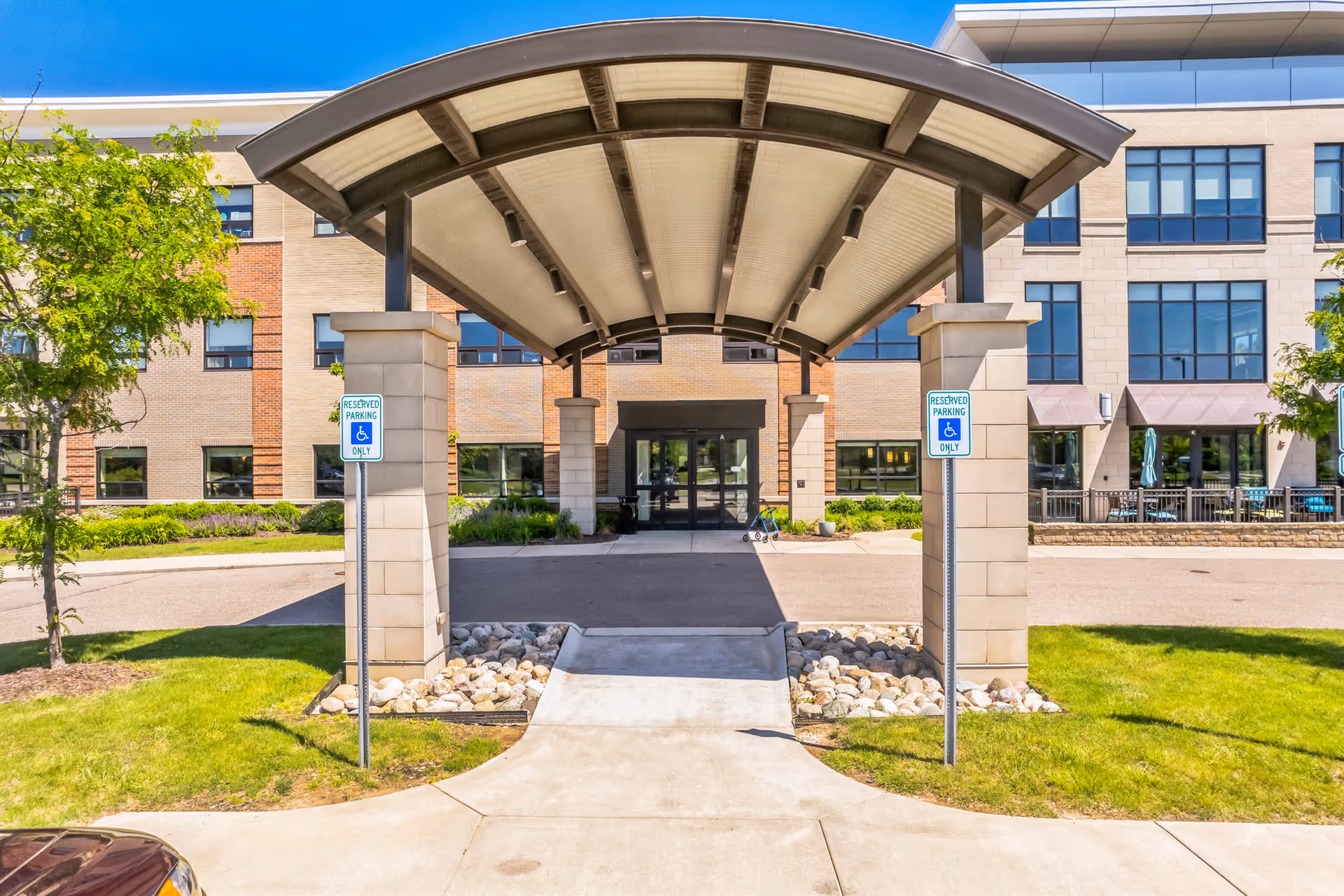 Exterior view of Willowbrook Hills entrance with curved canopy and walkway.