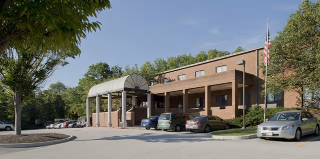 Exterior view of Courtland building with brick facade, parked cars, and entrance canopy.