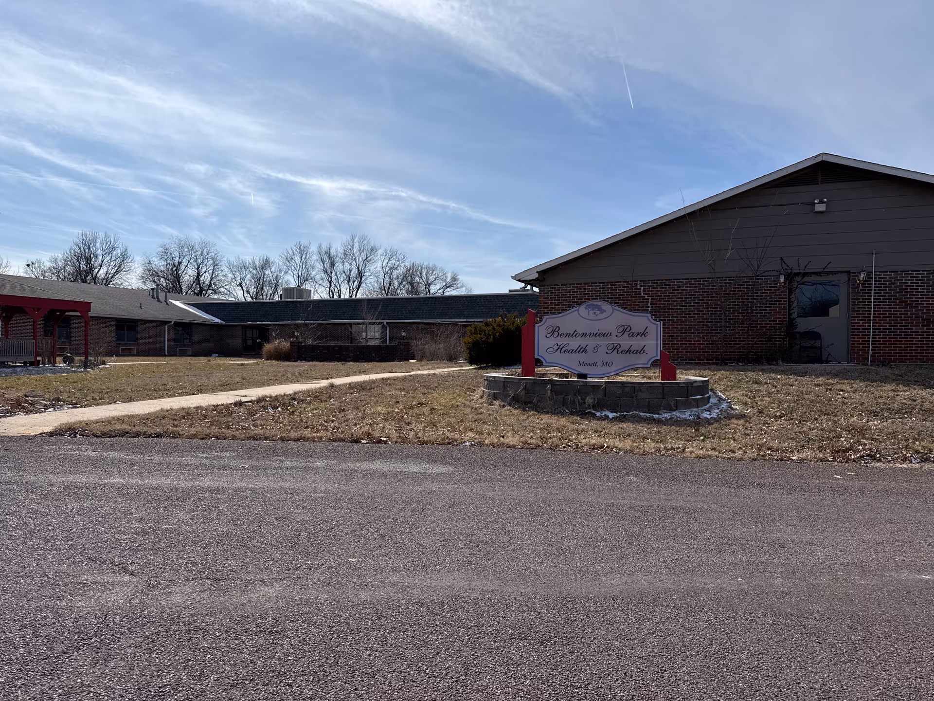 Exterior view of Bentonview Park Health & Rehab building with sign in front and clear sky