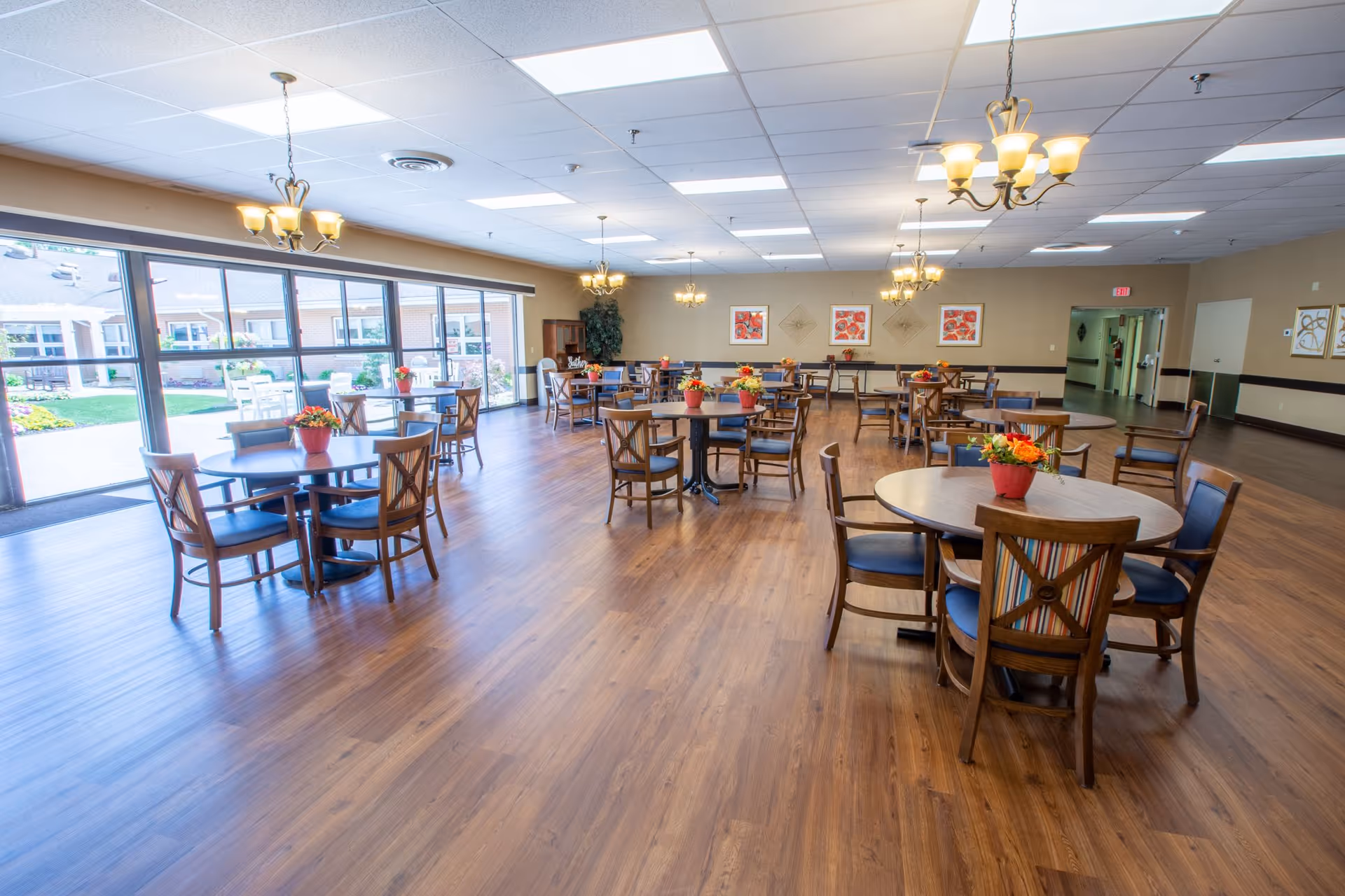 Timberland Ridge dining hall with round tables, chairs, and potted flowers.