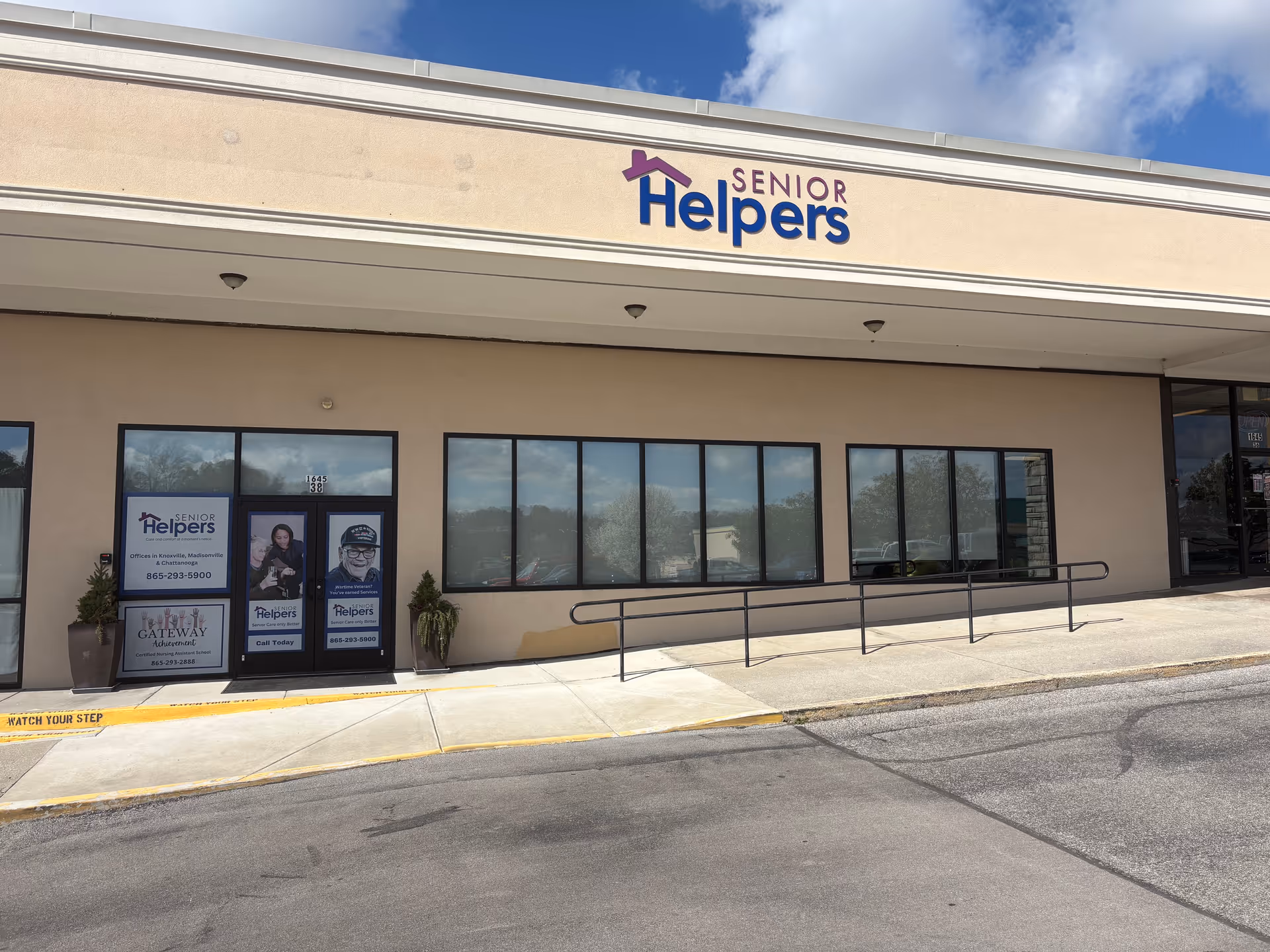 Front exterior of Senior Helpers of Knoxville storefront with beige facade and large windows.