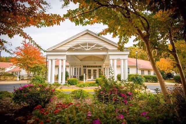 Front entrance of Solomons Nursing Center with white columns and landscaped garden.