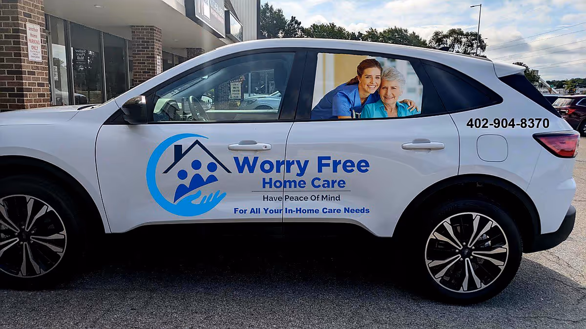 White vehicle with Worry Free Home Care logo parked outside a brick building.