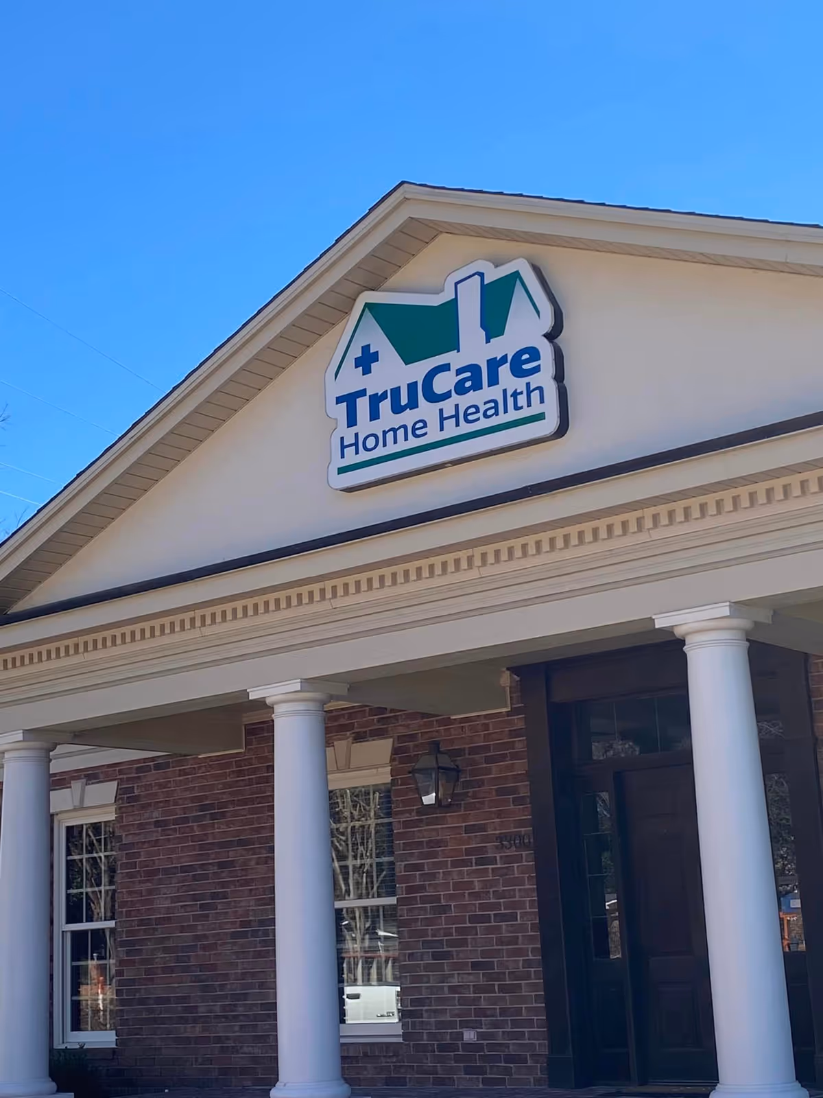 Front exterior of TruCare Home Health building with signage and brick facade.
