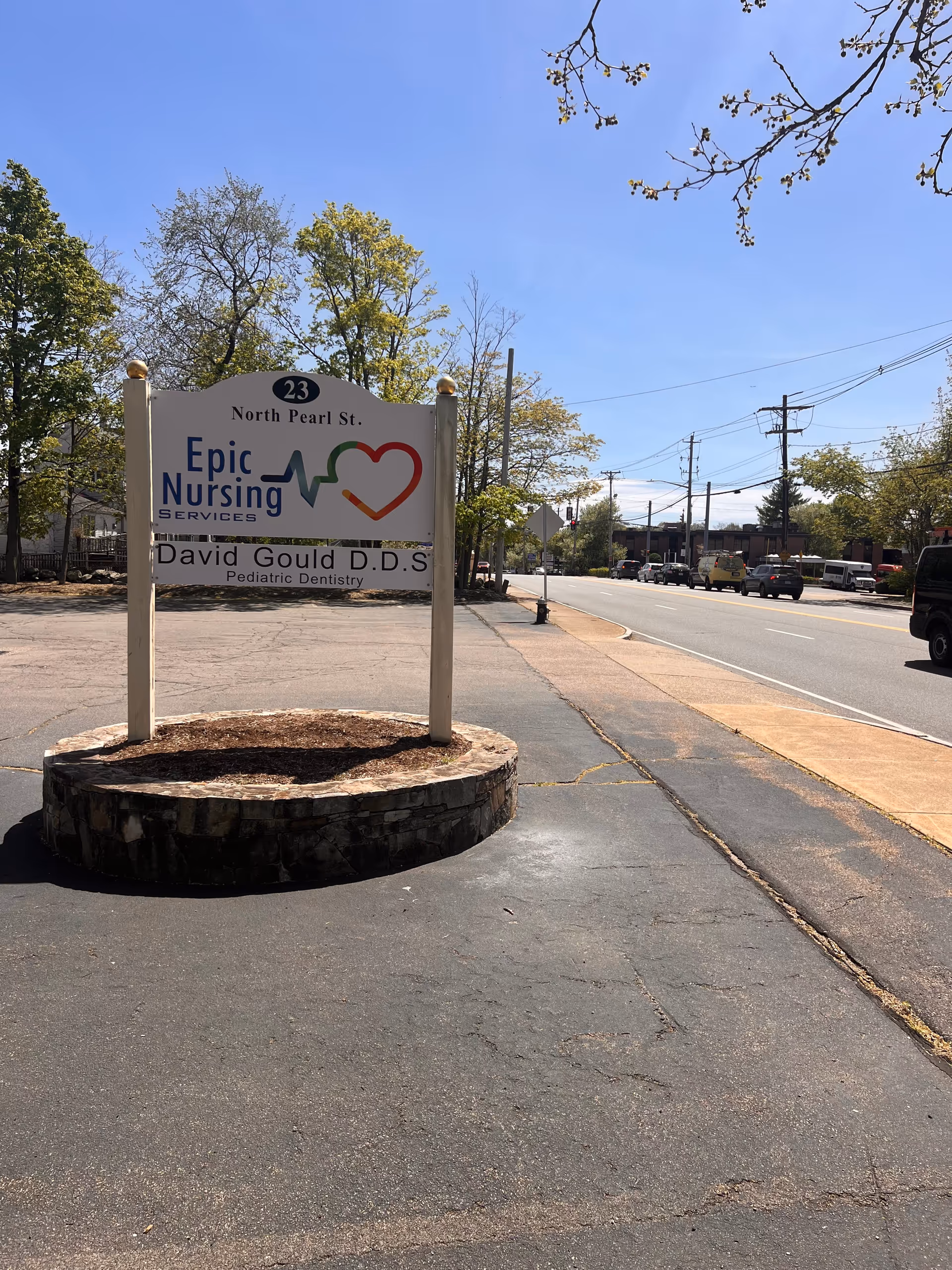 Outdoor street view of the Epic Nursing Services sign on a circular stone base.