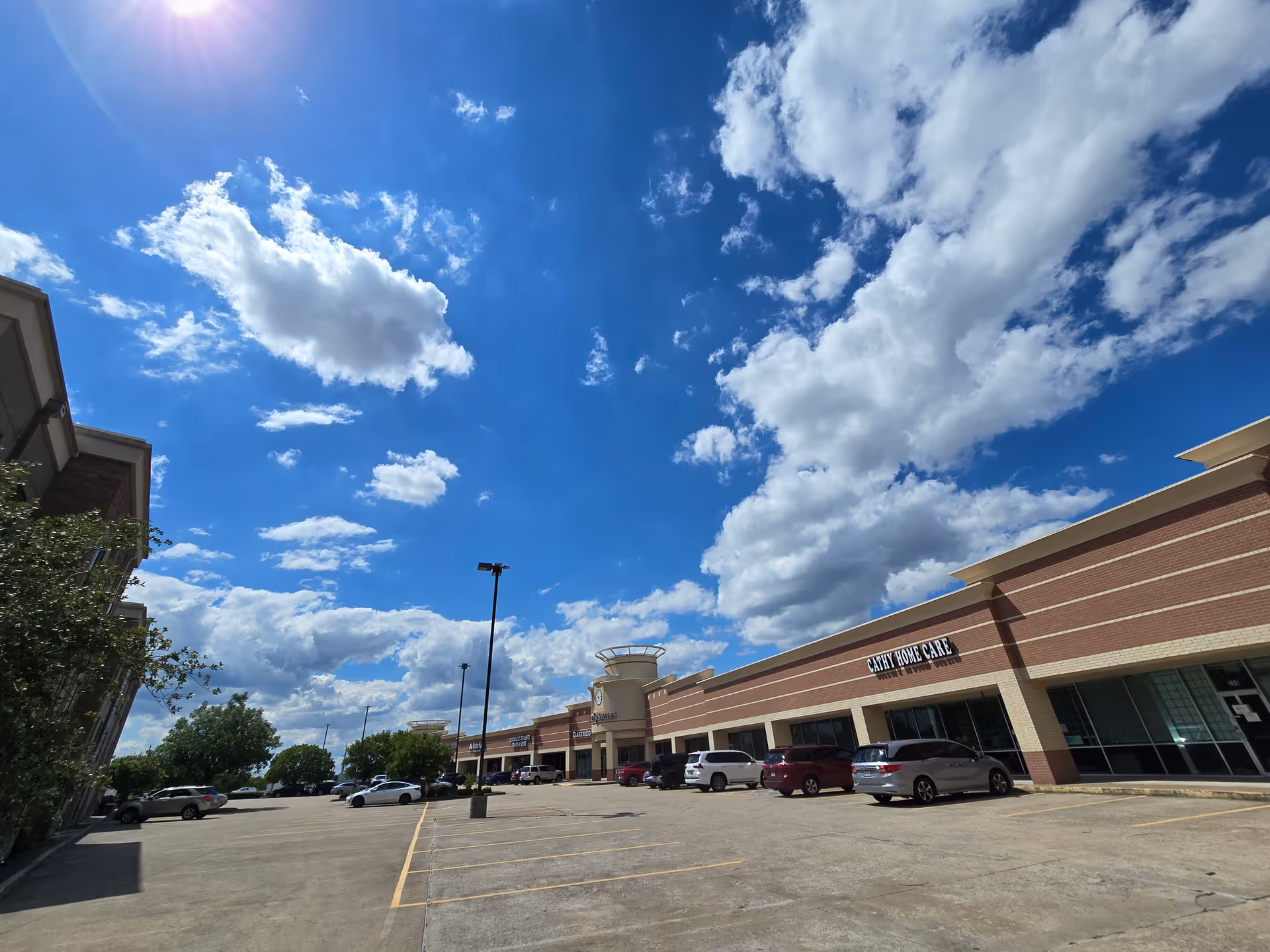 Sunny exterior view of Cathy Home Care building with parked cars in front
