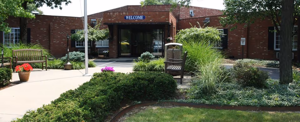 Exterior view of Franklin Meadows front entrance with brick building and greenery.