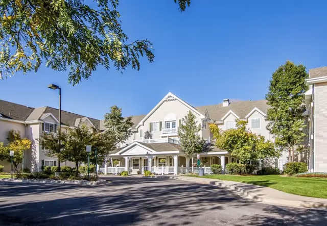 Front view of CuraVistas Highline senior living campus with covered entrance and landscaped grounds.