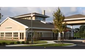 Exterior view of Highland Glen senior living facility with a covered entrance and parking area.