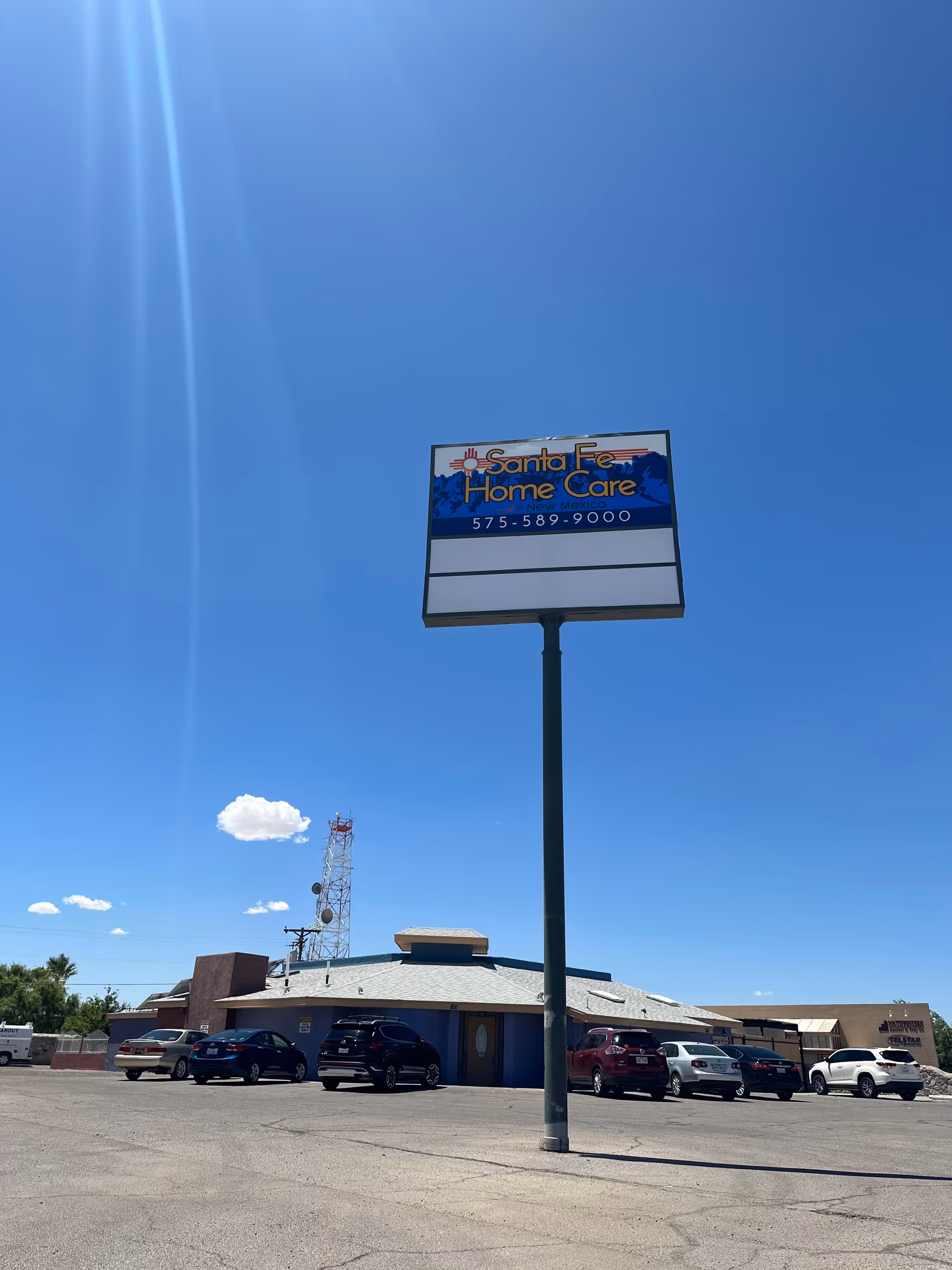 Tall Santa Fe Home Care sign over a low, single-story facility with parked cars.