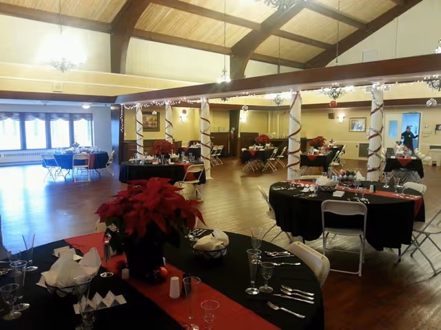 Lancashire Hall dining hall set for a banquet with decorated tables and poinsettia centerpieces.