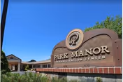 Exterior view of Park Manor Rehabilitation Center sign under blue sky.