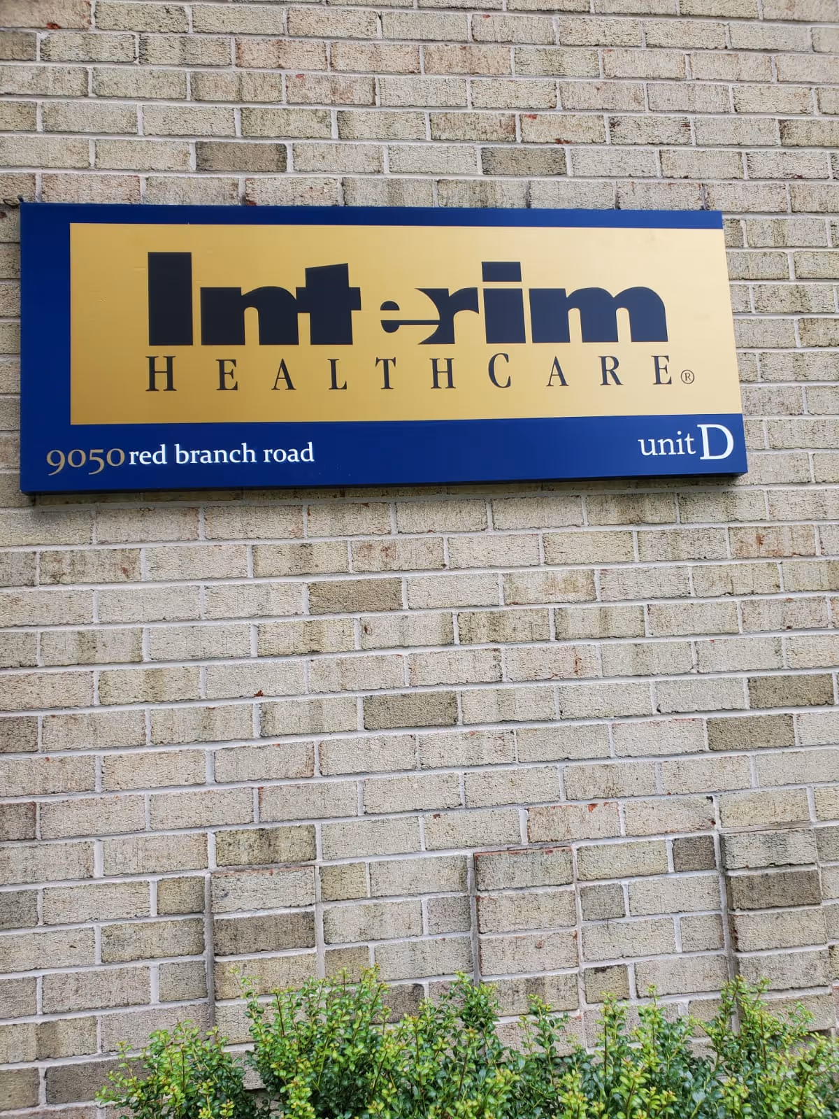 Interim HealthCare unit D sign mounted on a brick exterior wall.