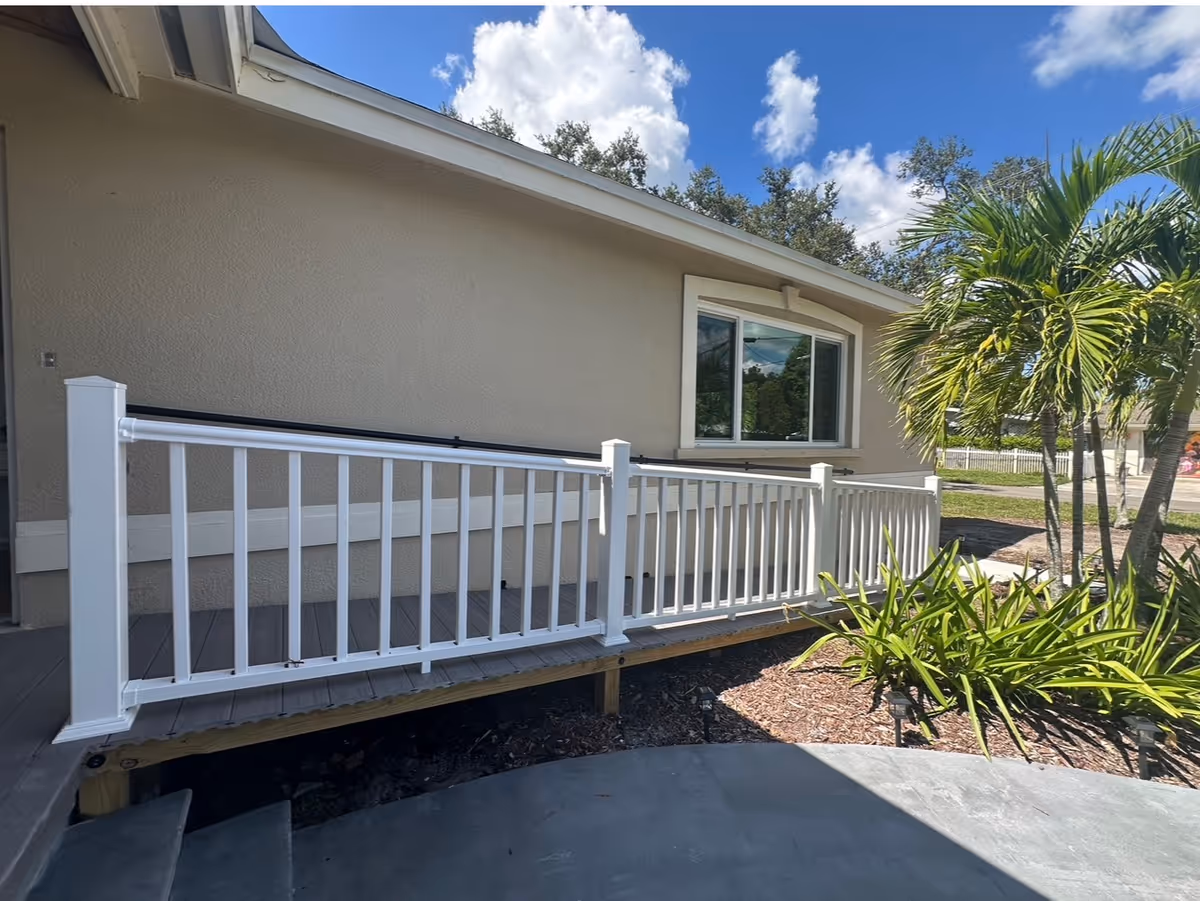 Exterior view of Constantine Assisted Living showing a white railing deck and landscaping.
