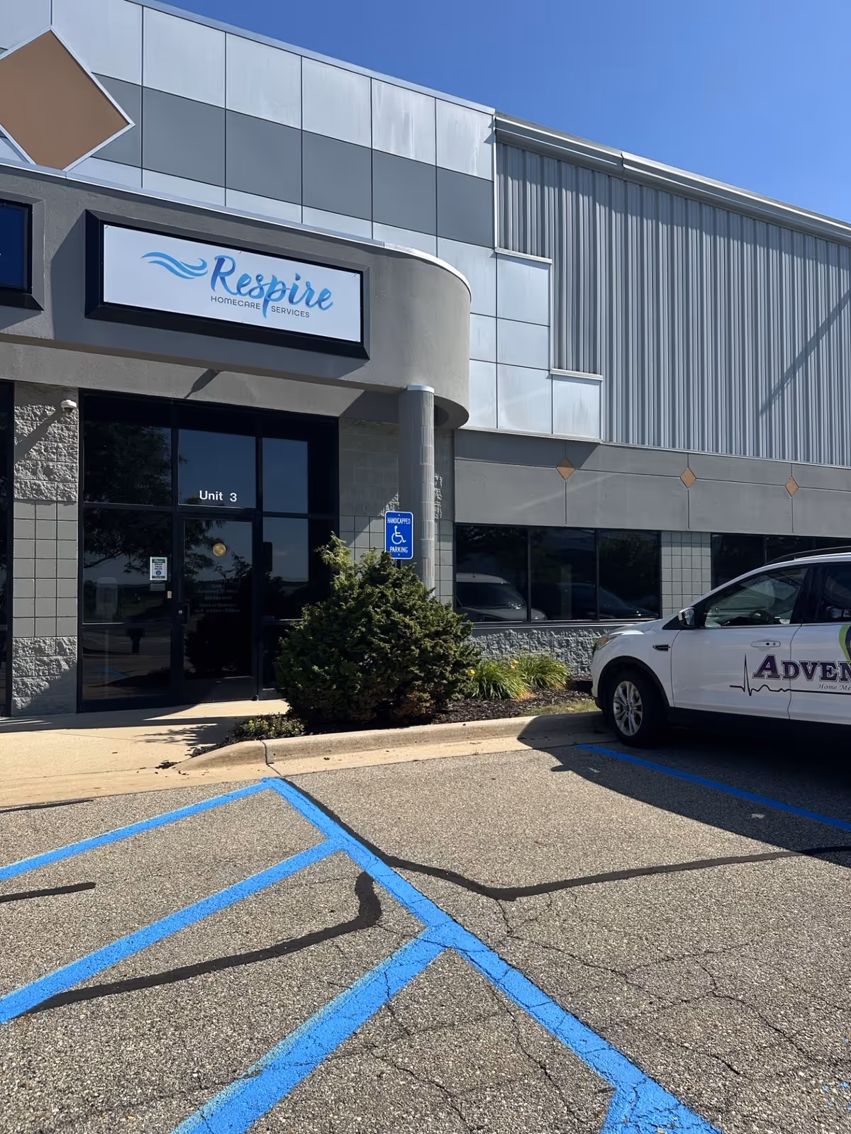 Exterior view of Respire HomeCare Services building with parking lot and handicap sign.