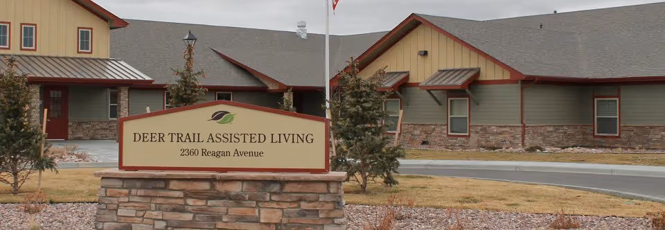 Front view of Deer Trail Assisted Living with a stone sign in the foreground.