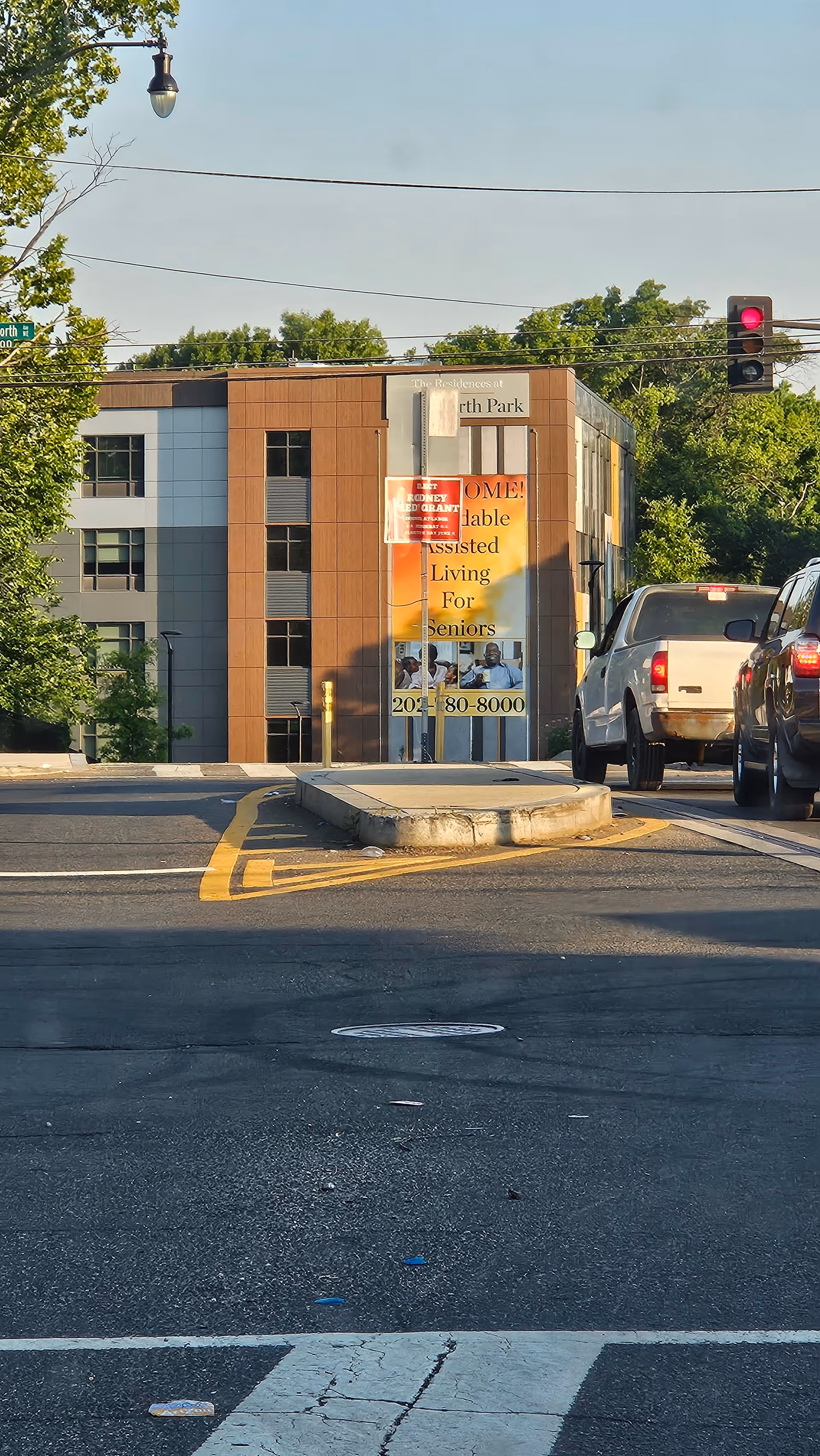 Exterior view of The Residences at Kenilworth Park with banner and traffic.