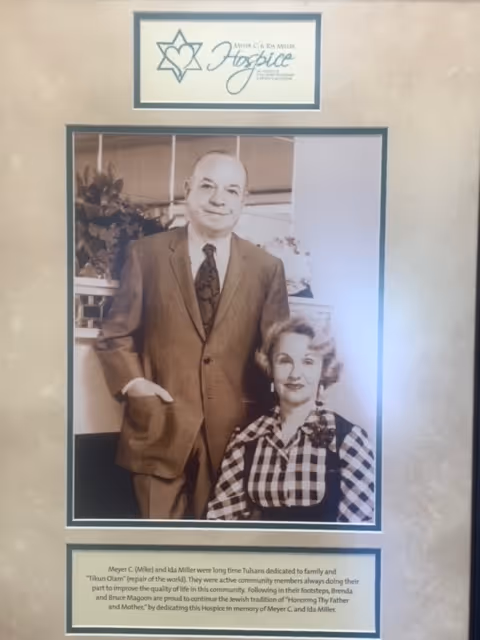 Framed vintage photo of a man in a suit with a woman on an interior wall.