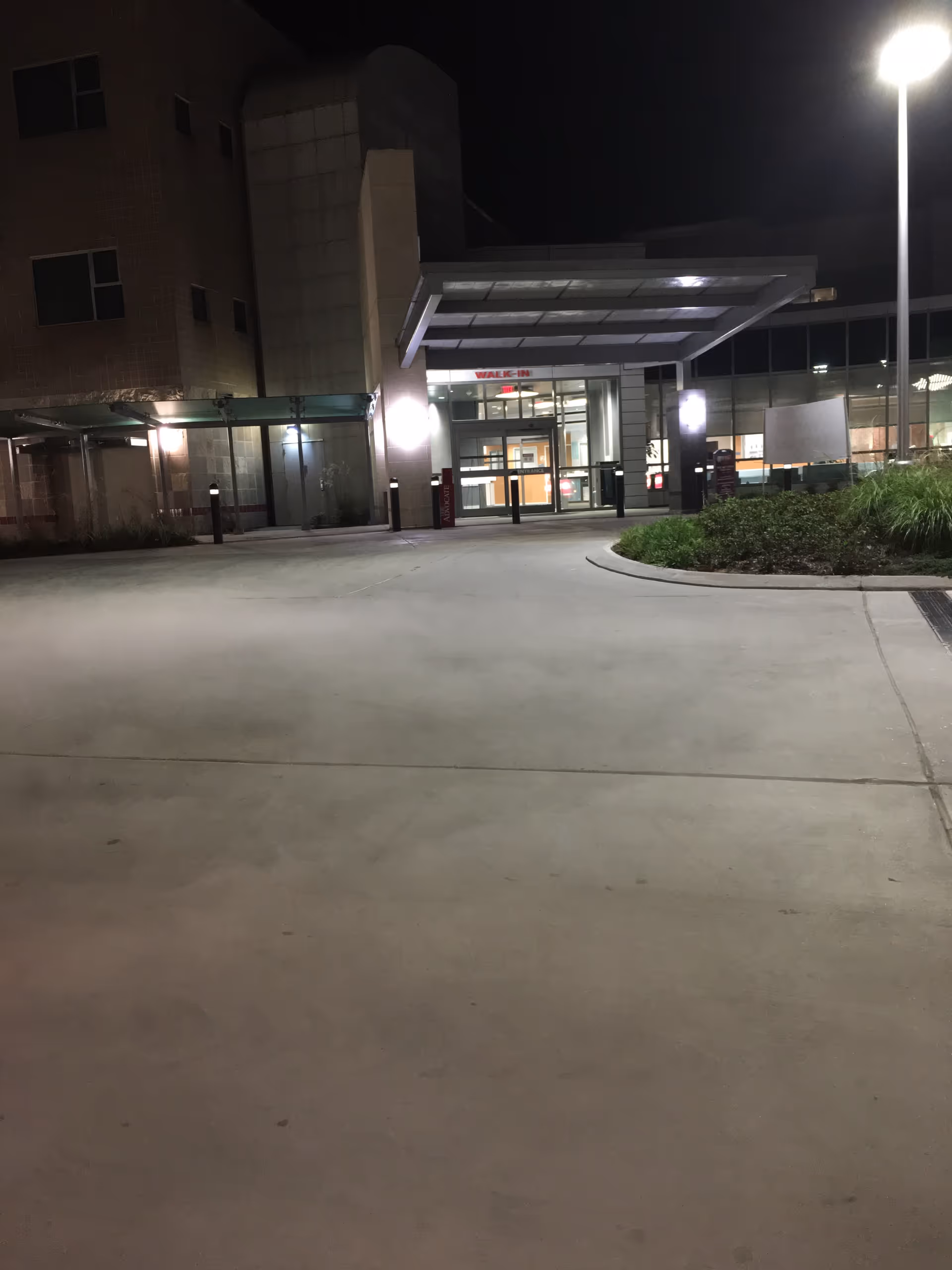 Night exterior of a senior healthcare facility entrance with glass doors and canopy.