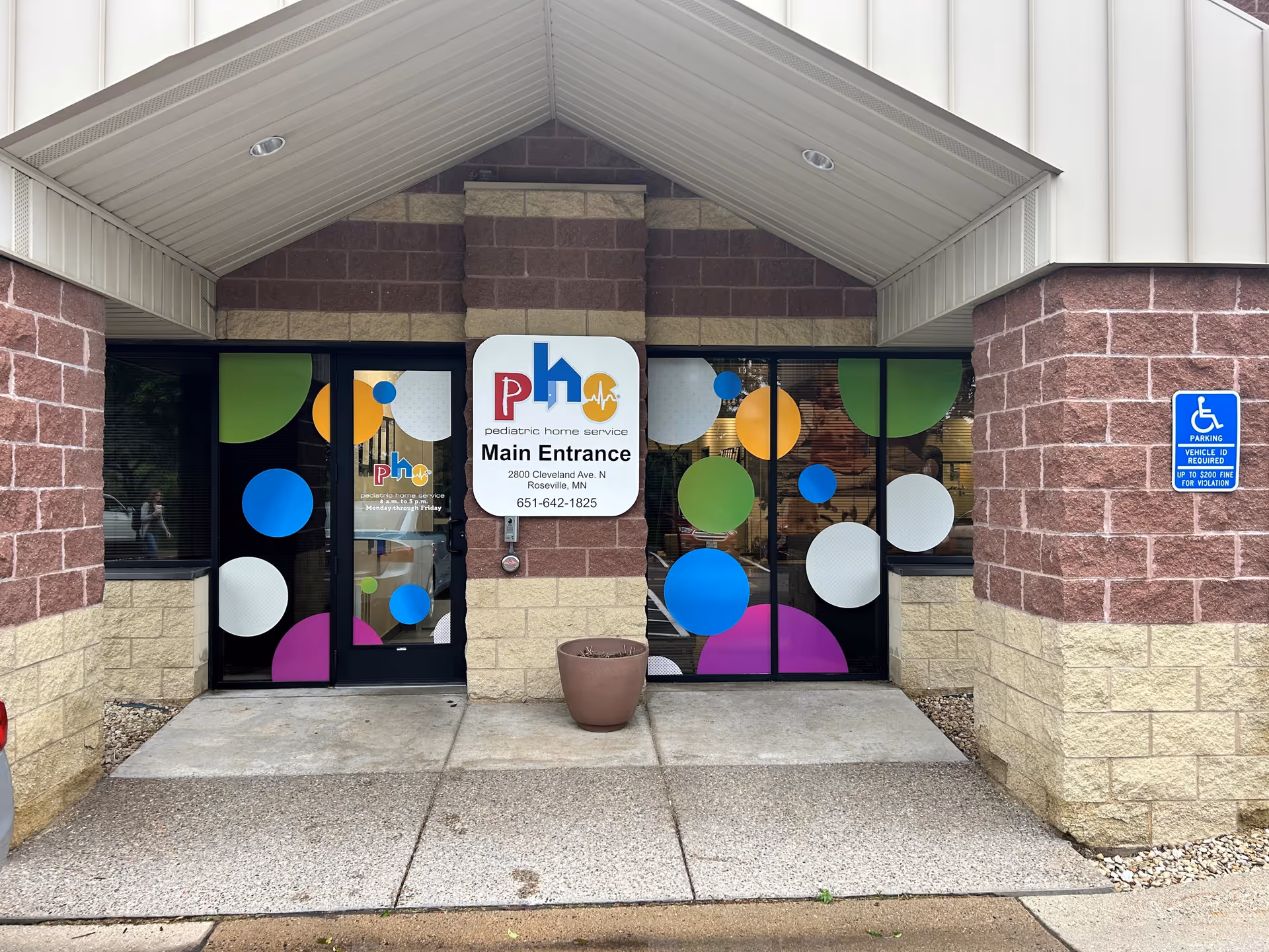 Exterior view of Pediatric Home Service entrance with colorful circular decals on glass doors.