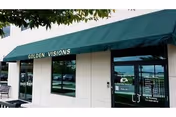 Exterior view of a building with a green awning reading Golden Visions.