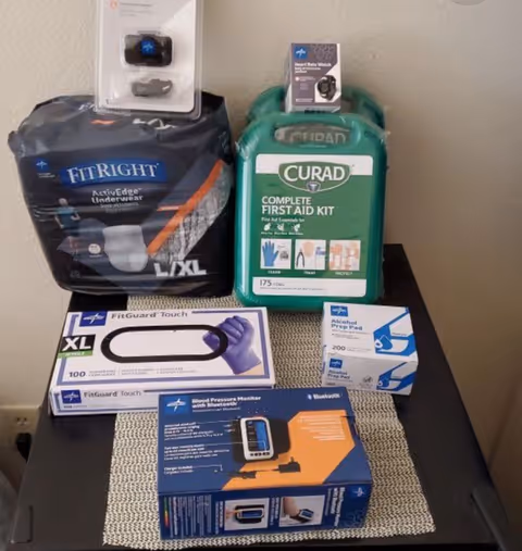 Medical supplies and a Curad first aid kit on a table indoors.