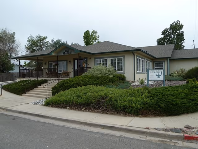 Exterior view of Aladdin Assisted Living facility with entrance and manicured landscaping.