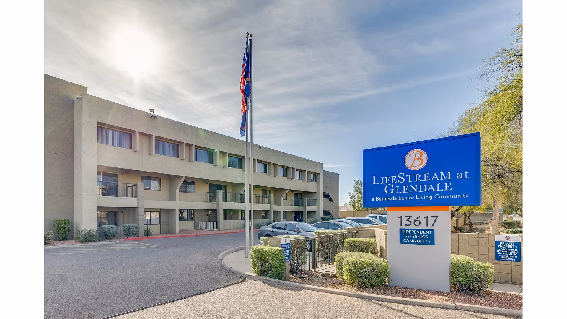 Exterior view of Lifestream at Glendale with blue sign, flagpole, and adjacent parking.