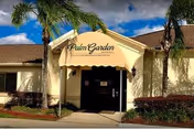 Entrance to Palm Garden of Jacksonville with an awning under palm trees.