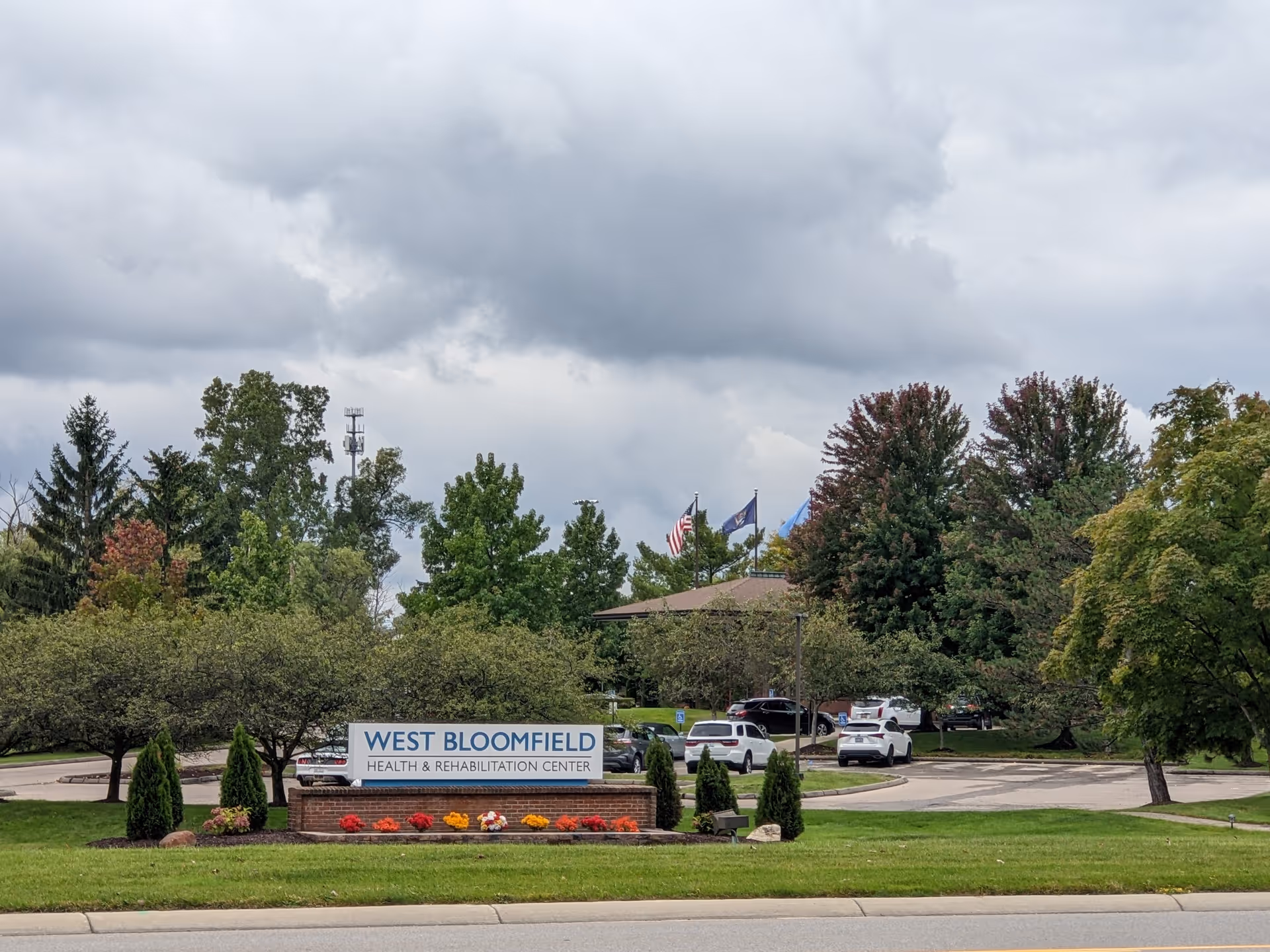 Exterior view of West Bloomfield Health & Rehabilitation Center sign with trees and cars