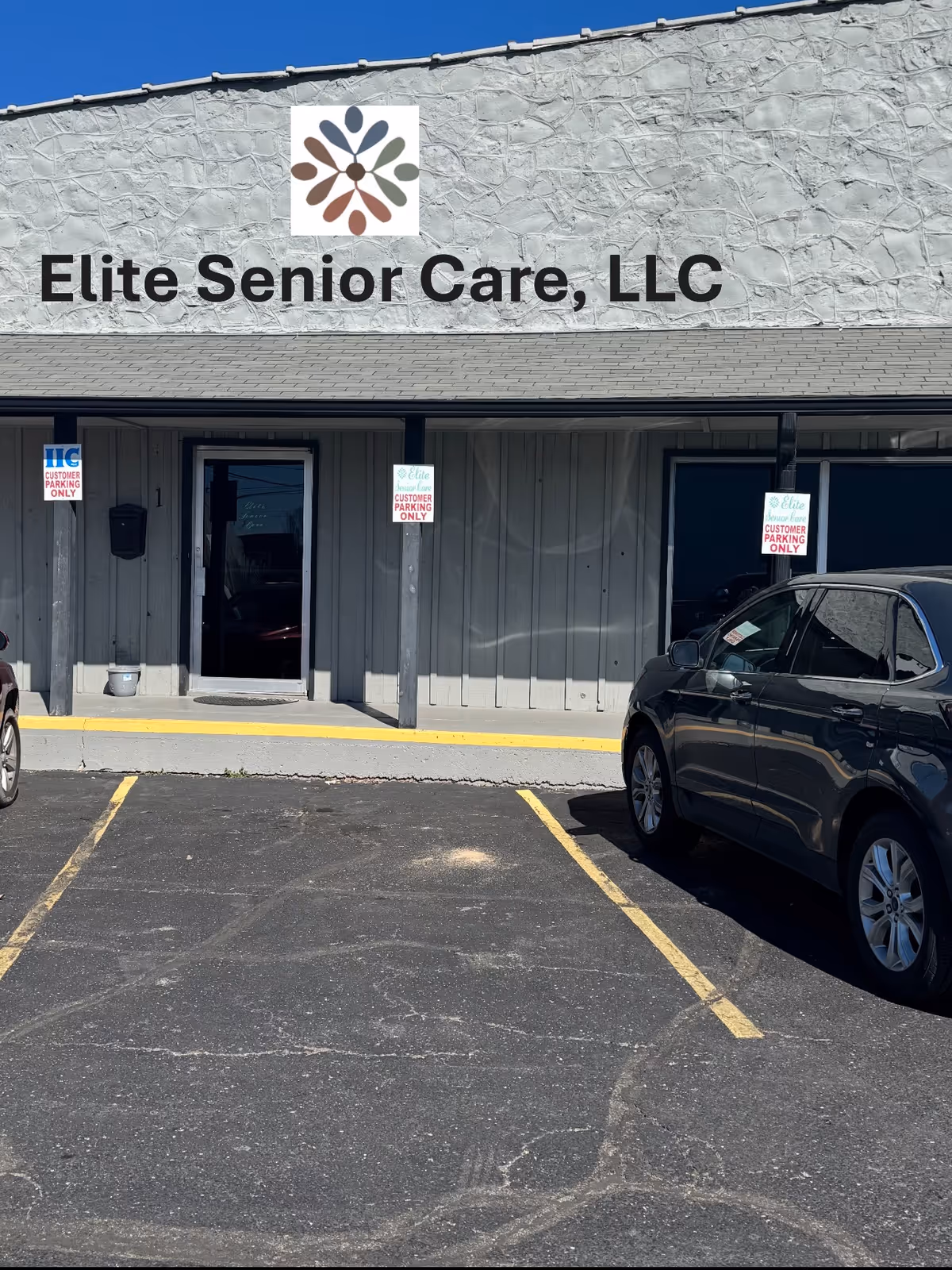 Front exterior of Elite Senior Care, LLC building with parking lot and cars.