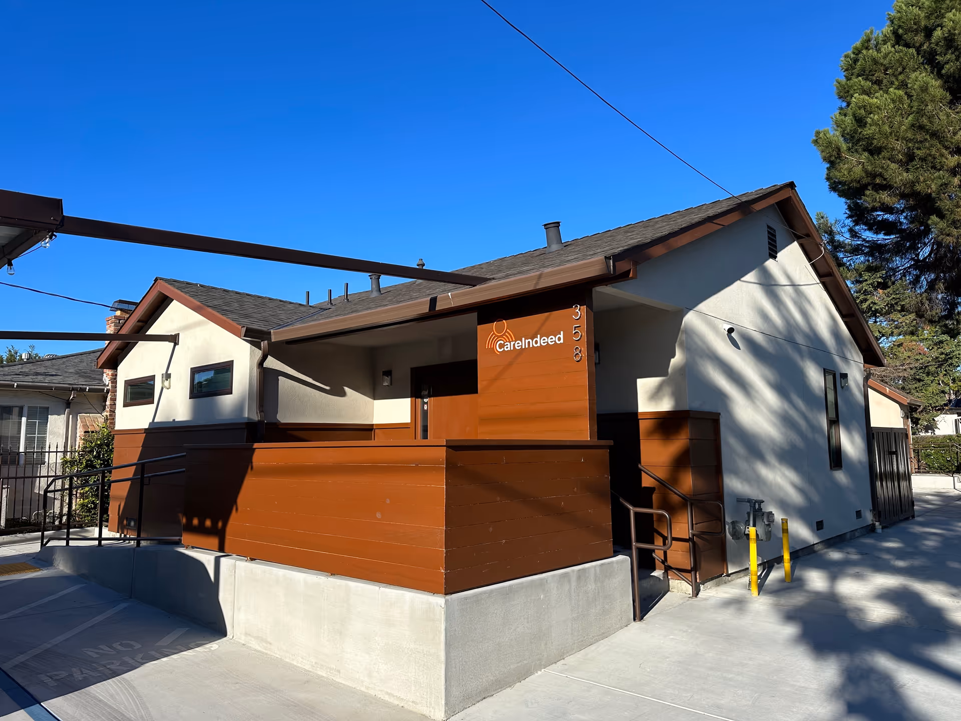 Exterior view of a Care Indeed senior living facility with brown and white facade and entrance.