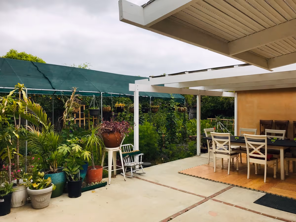 Outdoor patio at Hope Home Care for Elderly with potted plants and a dining table.