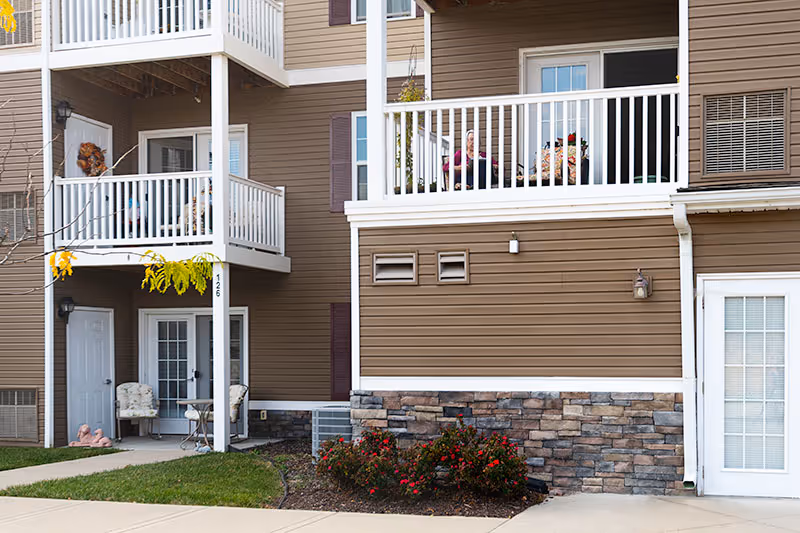 Exterior view of Connect55 Plus Independence with balconies, doors, and landscaped common area.