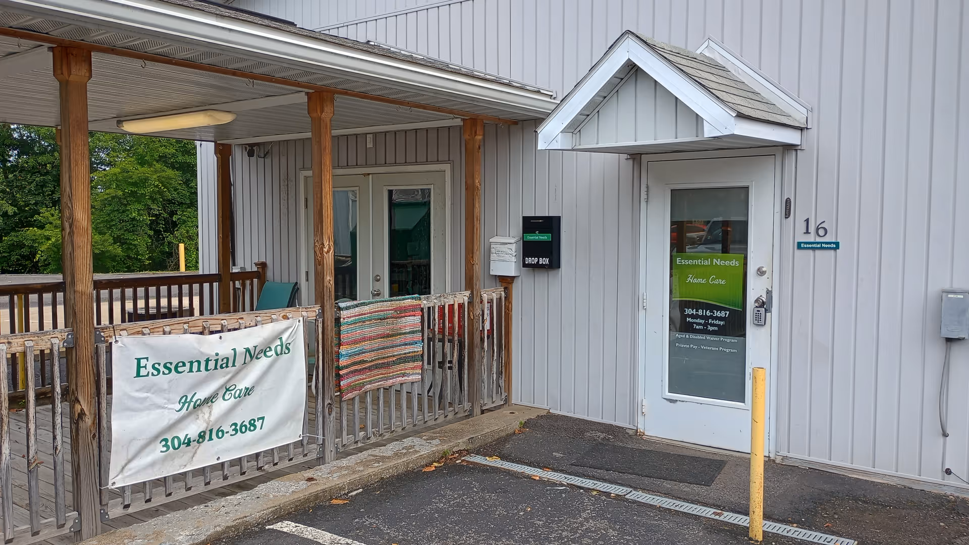 Exterior view of Essential Needs Home Care entrance with a covered porch and banners.
