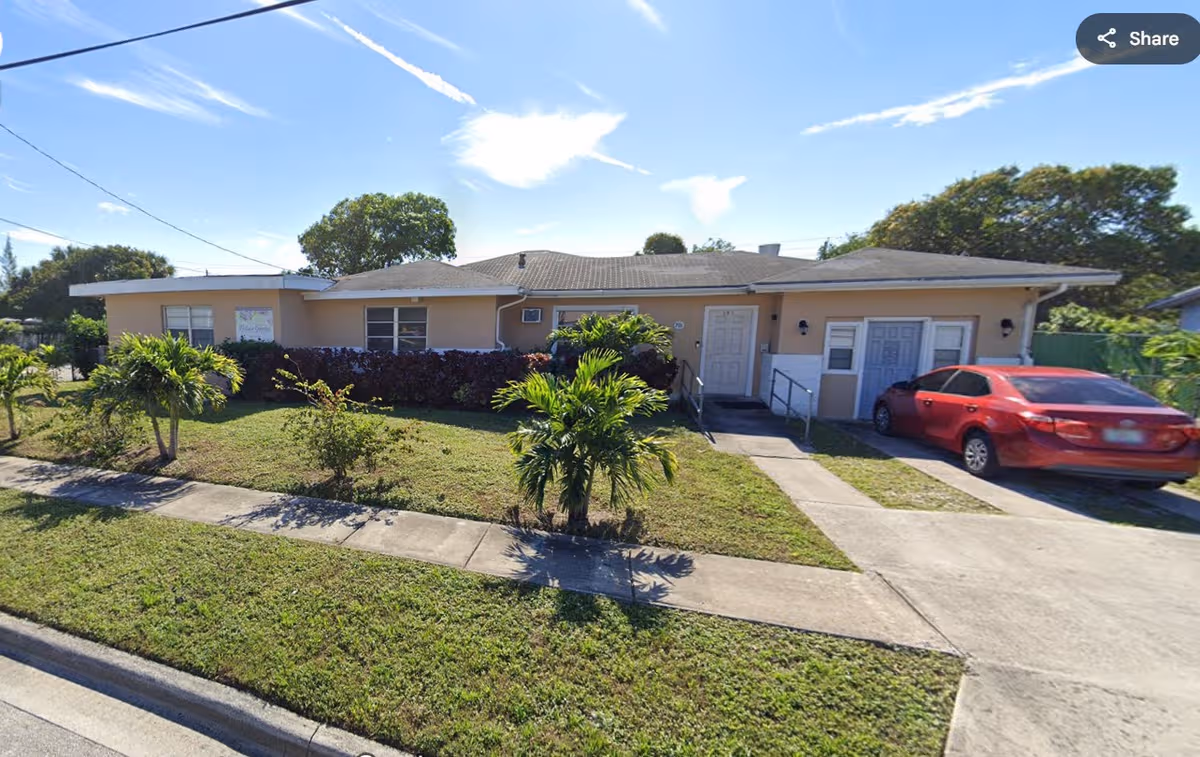 Victoria Gardens ALF exterior: single-story beige building with front entrance and driveway.