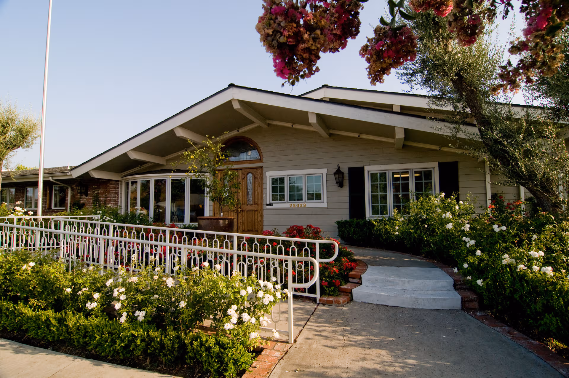 Front view of Canyon Oaks Nursing and Rehabilitation Center with ramp and flowering garden.