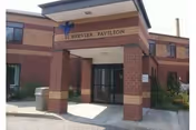 Exterior view of Schervier Pavilion entrance with brick archway and glass doors.
