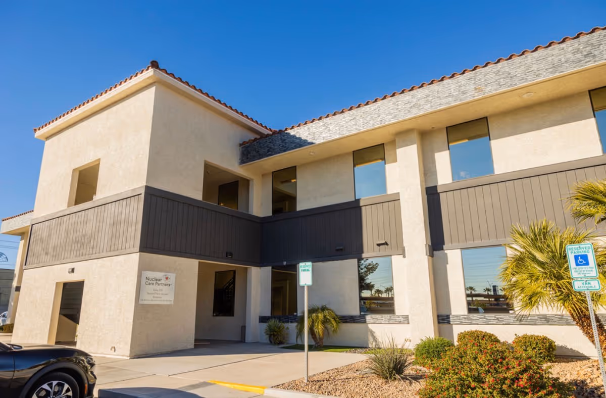 Two-story beige senior living building with brown balconies and a Nuclear Care Partners sign.