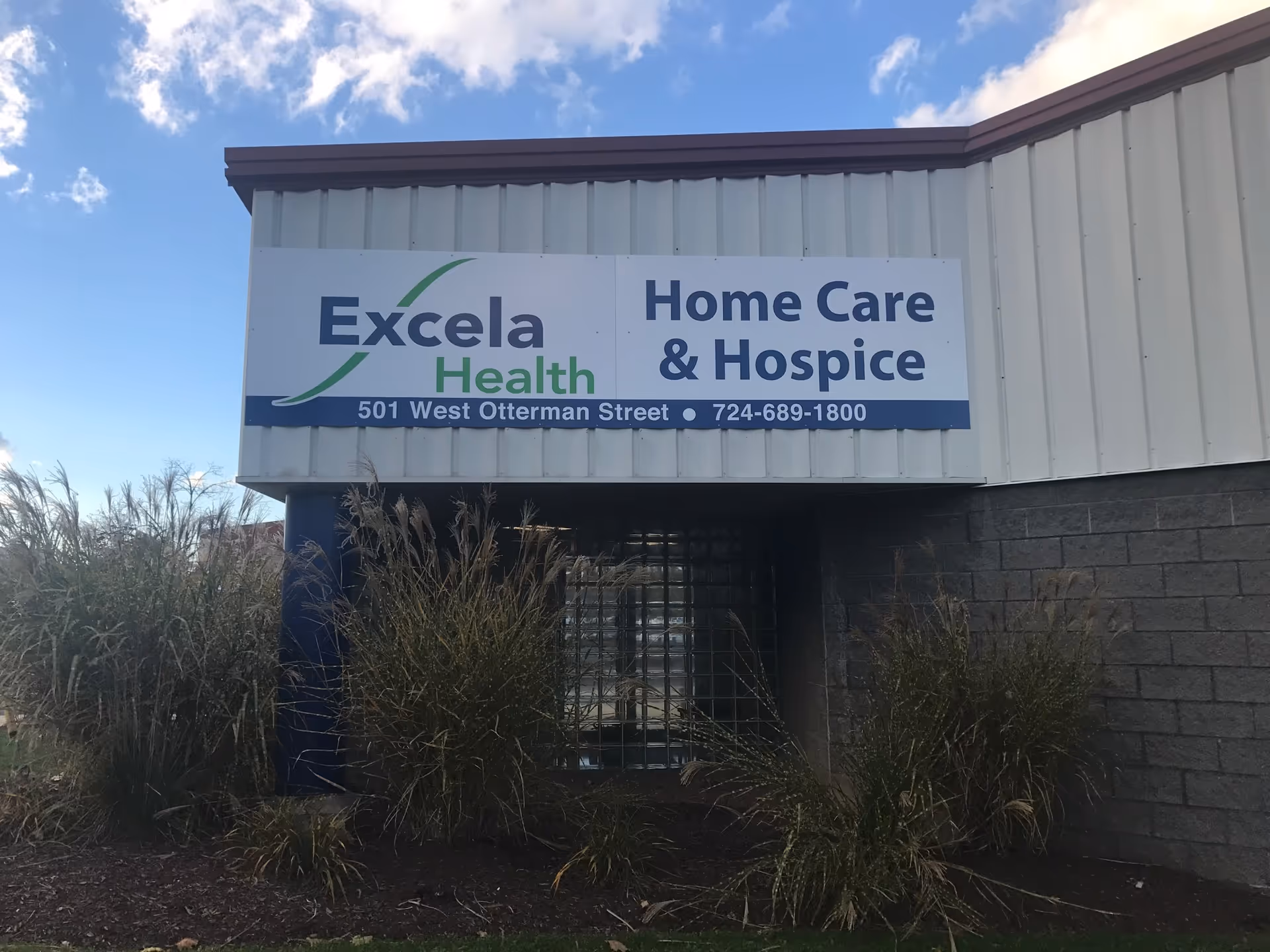 Exterior view of a facility sign reading Excela Health Home Care and Hospice.