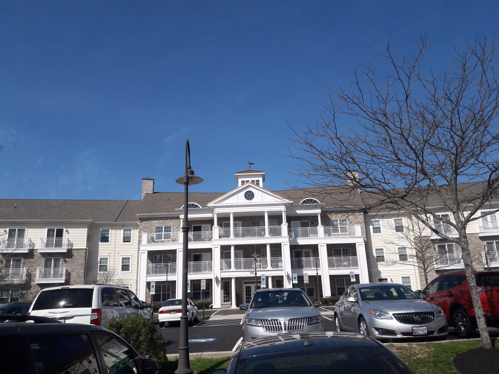 Exterior view of Brightview Avondell senior living campus with parked cars in front.