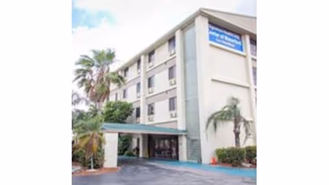 Exterior view of Waterford Rehab & Nursing Center building with entrance and palm trees.