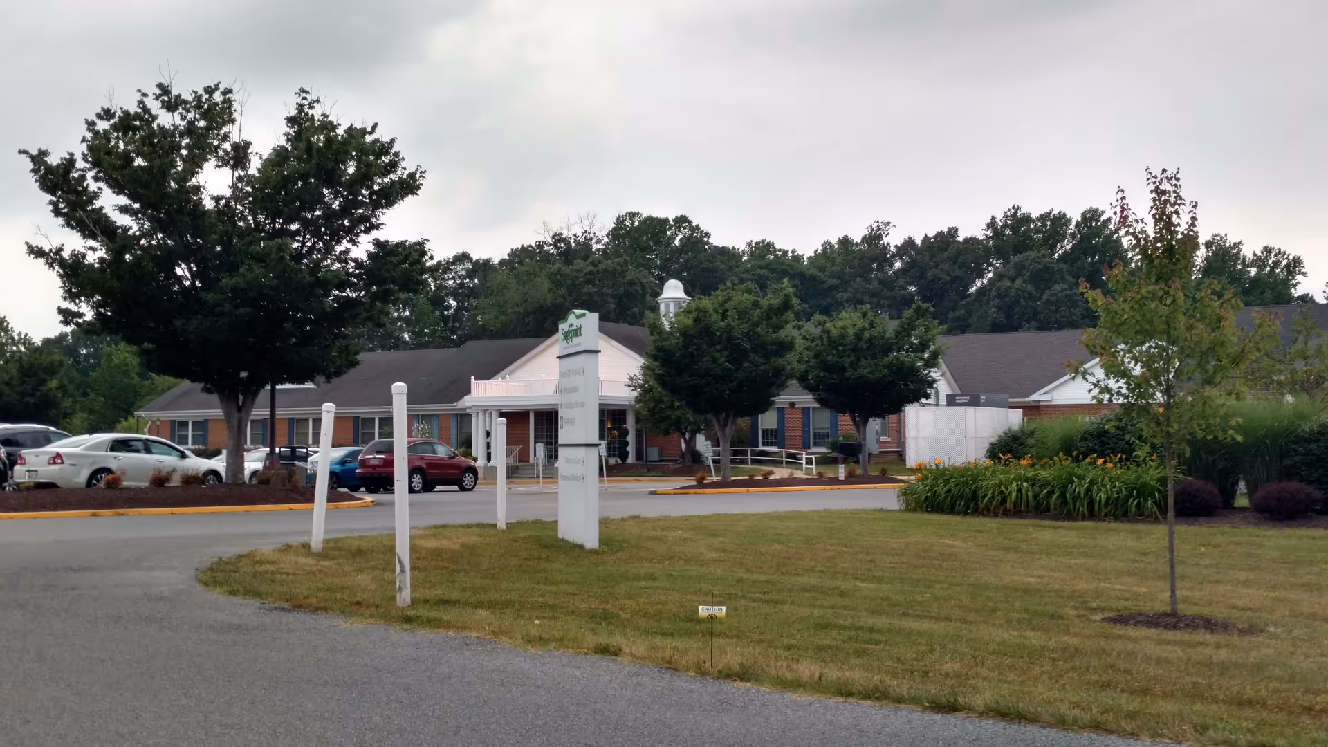 Exterior view of Sagepoint Memory Care building with parking and landscaping.